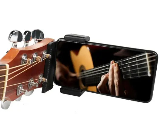 Kavon phone guitar clip stand attached to guitar for hands-free streaming and musician use during live performances.