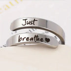 Silver stainless steel spiral heart ring engraved with "Just Breathe" by Kavon, showcasing its elegant design and polished finish.