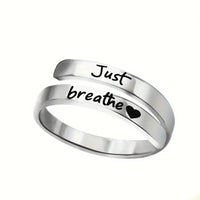 Stainless steel spiral heart ring with "Just Breathe" engraving by Kavon, silver jewelry featuring a heart-shaped design.