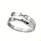 Stainless steel spiral heart ring with "Just Breathe" engraving by Kavon, silver jewelry featuring a heart-shaped design.